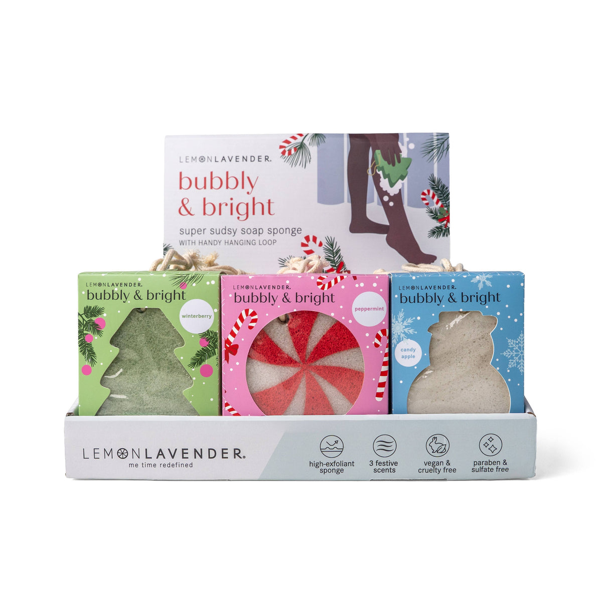 Set of four Lemon Lavender Bubbly and Bright Super Sudsy Soap Sponges in holiday-themed packaging with tree and peppermint designs, arranged in a branded tray. Sizes available.