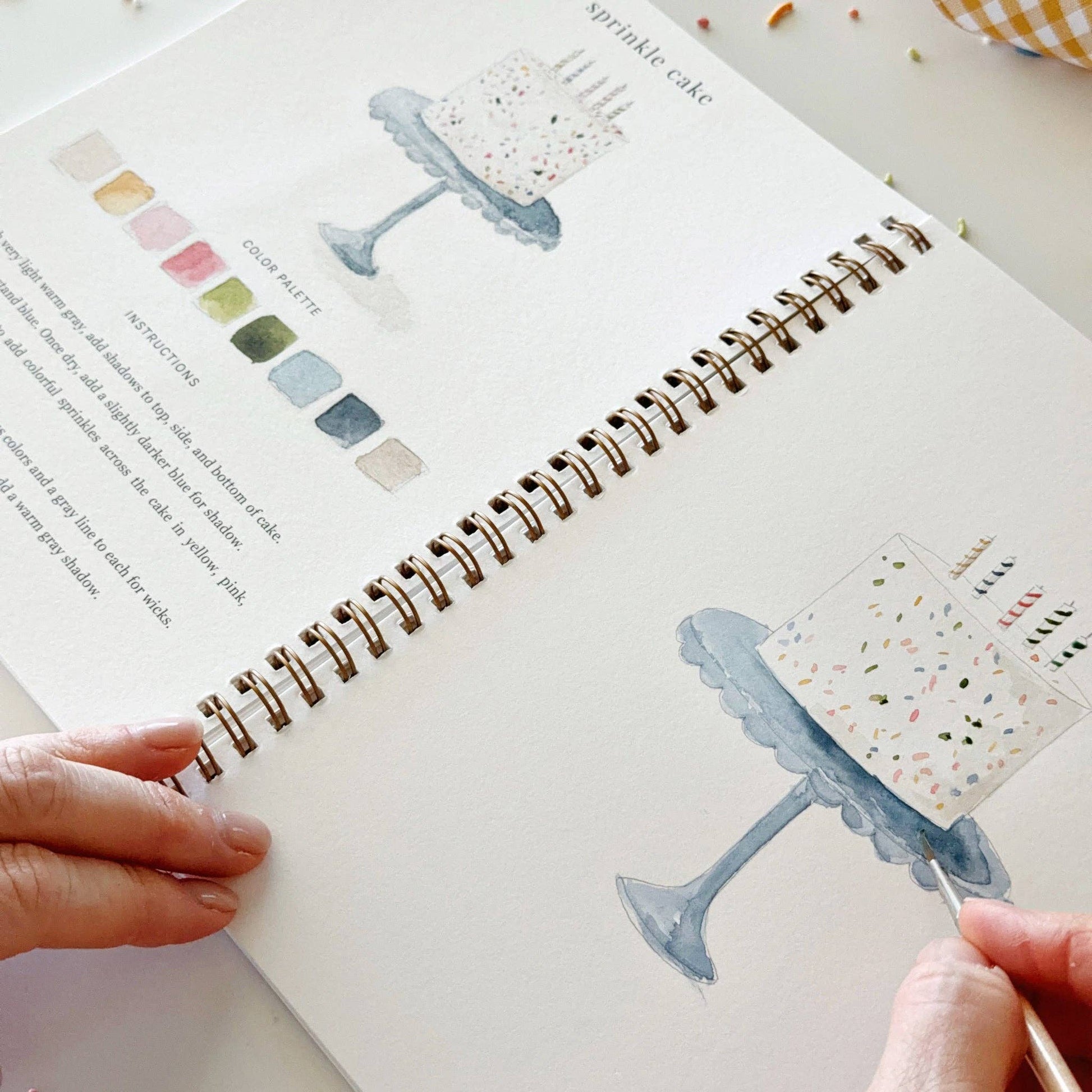Celebrate watercolor workbook with cake illustration, color palette, and step-by-step instructions; available in standard A4 and A5 sizes.