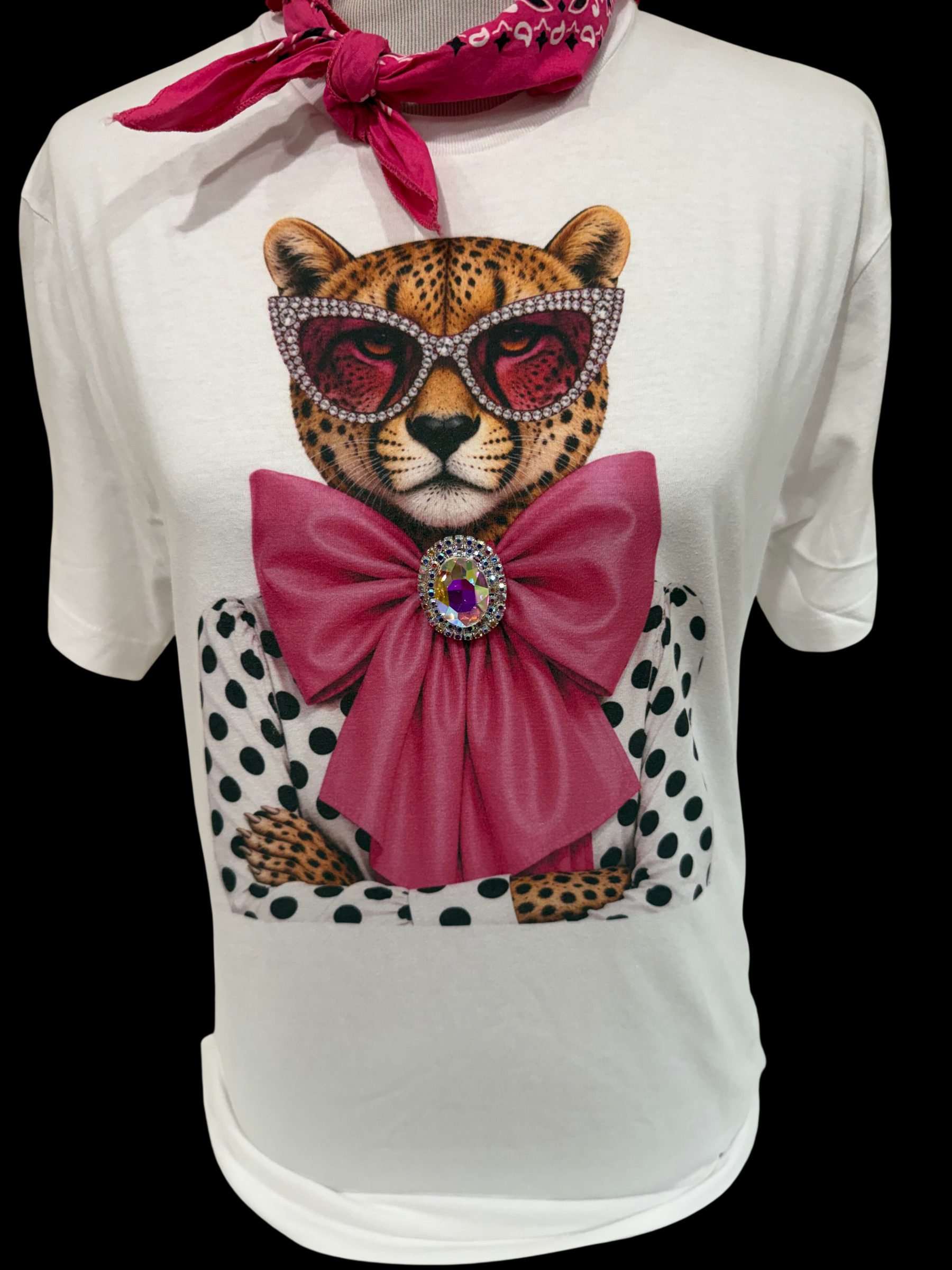 White crew t-shirt with a leopard graphic featuring heart sunglasses, a polka dot jacket, a large sparkling pink bow with rhinestone brooch, and a pink bandana. Available in size L.