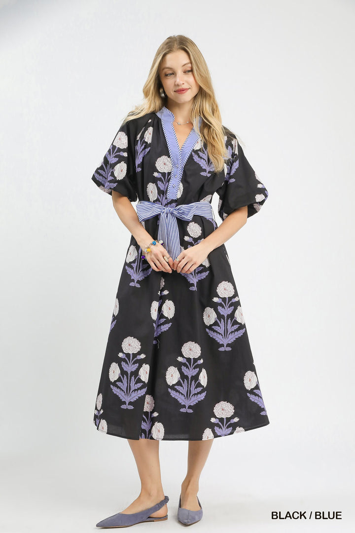 Carol Floral Print Midi Dress in blue and white florals with striped belt. Sizes: XS-XL. "BLACK / BLUE" text shown.