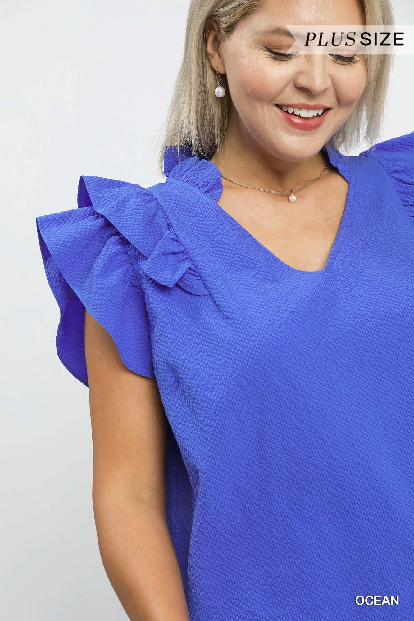 Mila Textured Ruffle Blouse in vibrant blue with ruffle sleeves, available in plus sizes.