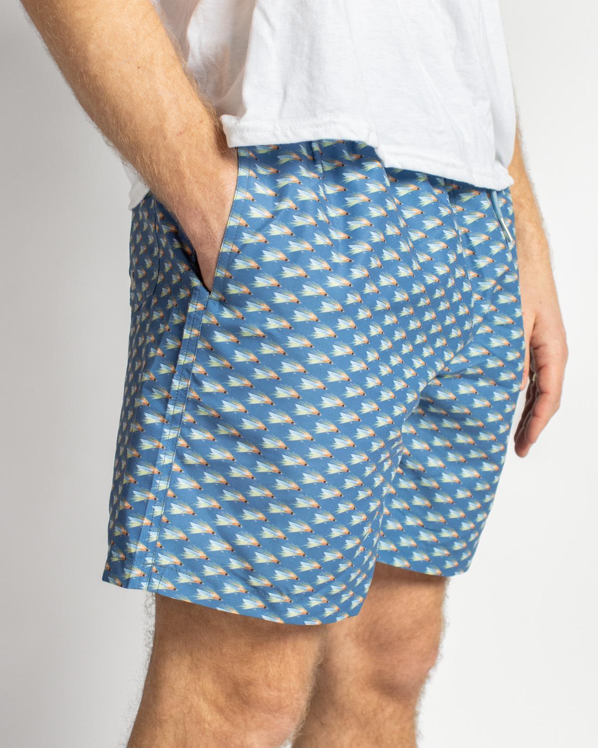 Men’s On The Fly Swim Trunks in blue geometric pattern. Available sizes: S-XXL. Only the shorts are shown, no model detail.