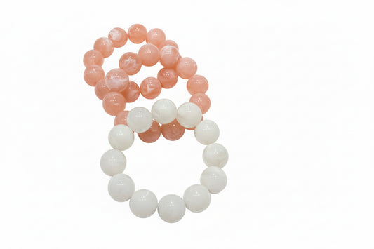 Set of two beaded bracelets: one marbled peach, one white; available in S/M and M/L sizes.