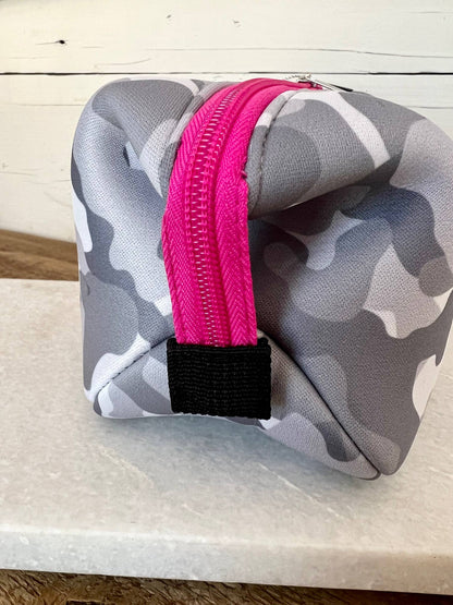 The Olivia Small Neoprene Makeup Bag is gray and white camo with a pink zipper and black loop, available in small size.