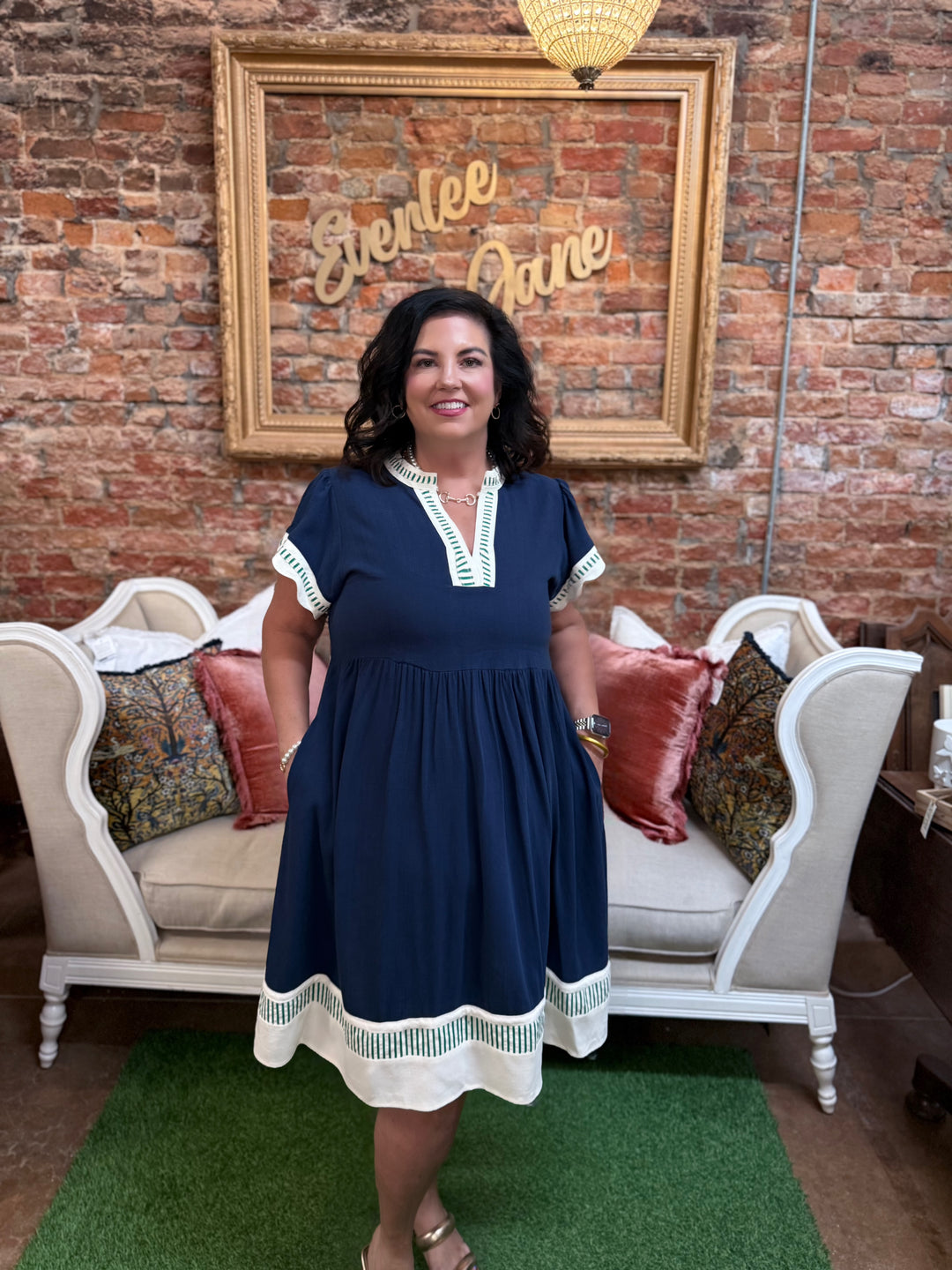 Navy Coast Linen Color Block Dress in navy blue, knee-length tiered silhouette, split neckline, short sleeves, white and green patterned trim. Available in sizes XS-XL.
