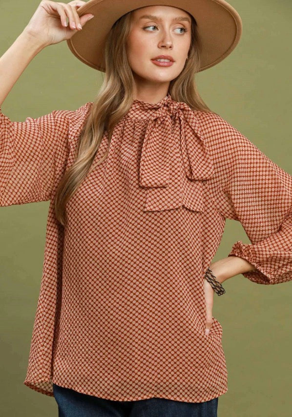 Dottie Tie Top: patterned, long-sleeve blouse with bow at neck; available in sizes XS–XL.