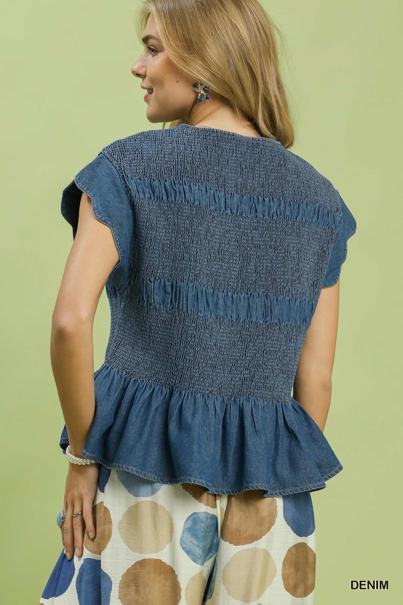 Blaire Chambray Smocked Peplum Top with short sleeves, smocked bodice, and ruffle cap sleeves. Available in sizes XS–XL.