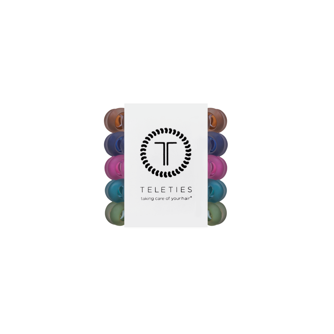 Pack of Sweater Swatches Tiny Hair Ties in assorted colors, mini spiral bands arranged vertically with a central white label featuring the brand logo and “taking care of your hair” slogan. Available in mini size.