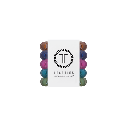 Pack of Sweater Swatches Tiny Hair Ties in assorted colors, mini spiral bands arranged vertically with a central white label featuring the brand logo and “taking care of your hair” slogan. Available in mini size.