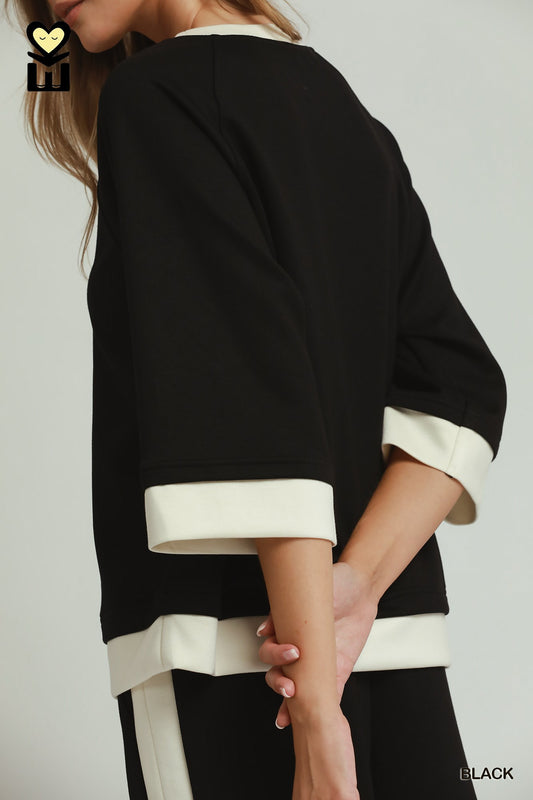 Black colorblock crewneck raglan sleeve top with white cuffs; available in sizes S-XL.