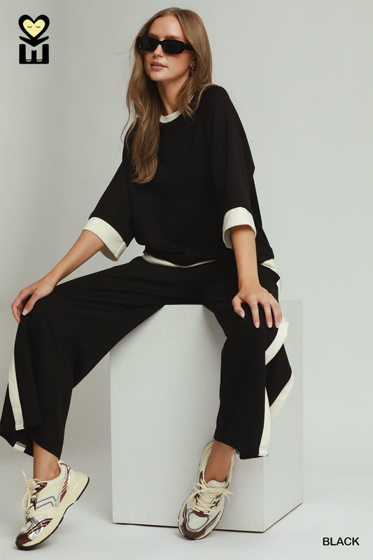 Black Colorblock Crewneck Raglan Sleeve Top with white trim, available in sizes XS-XL.