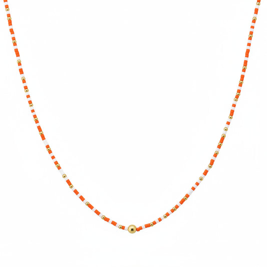 The Cleo Orange White Beaded Necklace features alternating small orange and gold beads with a larger gold bead at the center. Available in multiple sizes.