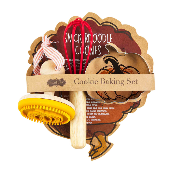 Fall Cookie Baking Set includes a yellow stamp, red whisk, pumpkin-shaped cookie cutter, and recipe cards. Packaged with a brown paper band labeled “Cookie Baking Set.” Sizes available: standard.