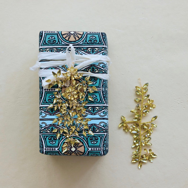 Gold-toned, leaf-shaped Acrylic Wired Jeweled Ornament with faceted zircon detail.