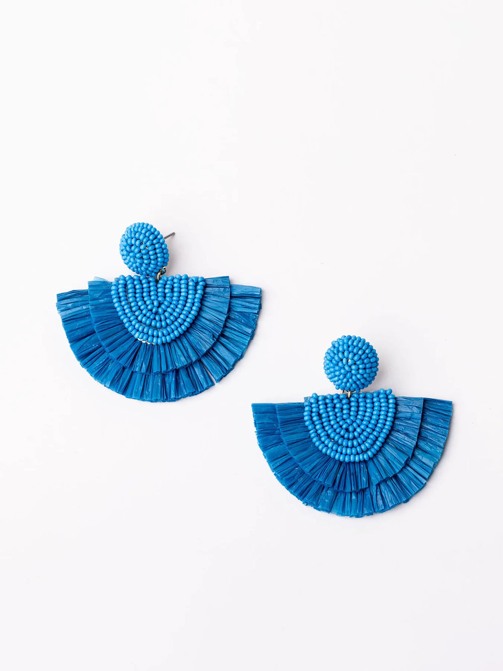 Bright blue raffia earrings with round beaded studs and fan-shaped fringe. Available sizes: Small, Medium, Large.