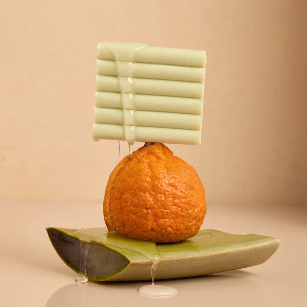 Pale green Glycolic Acid Exfoliating Face and Body Wash bars with suds. Available in 100ml and 240ml sizes.