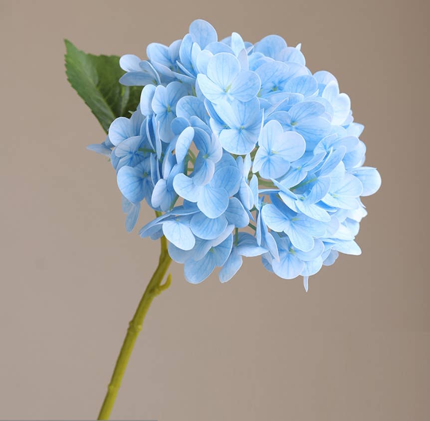 12.5" Real Touch artificial hydrangea with 6” soft pink bloom and green leaves; available in 12.5" size.