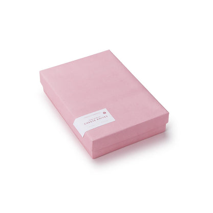 Rectangular pink gift box with a white label featuring red text on the top left corner. Perfect for presenting the Pink Blush Set of 3 Cheese Knives. Available in one size.