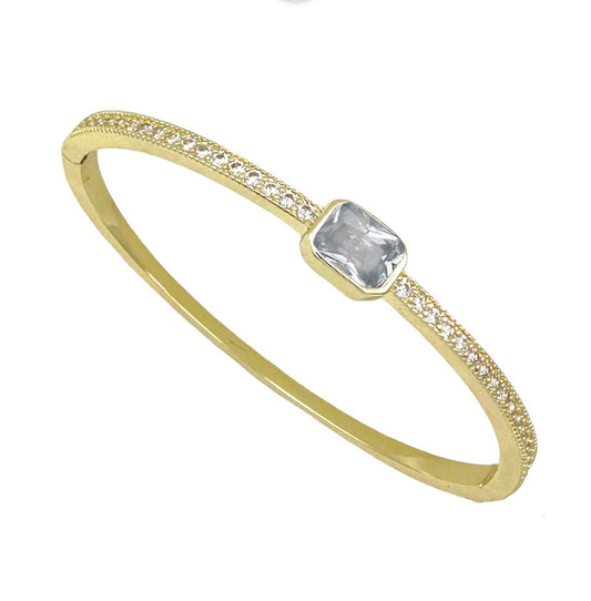 The Hank Gold Bangle features a rectangular crystal center with round diamond accents on the band. Available in S, M, L.