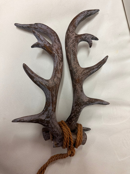 Two brown, weathered deer horns tied with thick brown rope at the base. Available in small and large sizes.