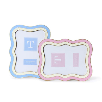 Two-Tone Waves 5"x7" frames: light blue with gold trim, light pink wavy edge, both feature a “T” logo insert.