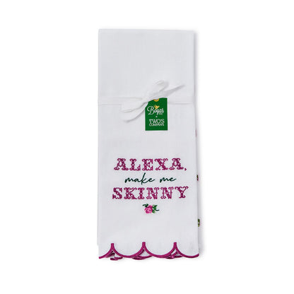 The Alexa Kitchen Dish Towel is crafted from soft white cotton with a scalloped purple border. It features "Alexa, make me skinny" embroidery and floral accents. Available size: standard kitchen towel size.