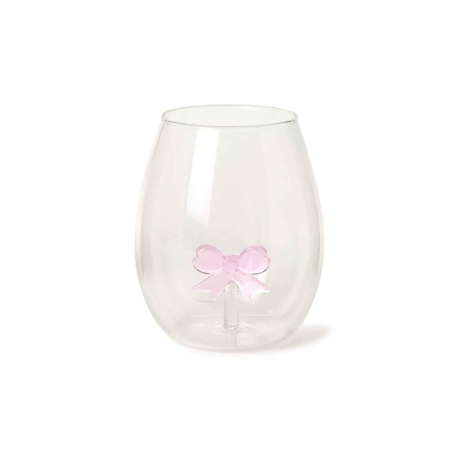 The Bow Stemless Wine Glass features a teardrop shape with a smooth surface and a unique double-walled design showcasing a pink bow. Sizes available: 12 oz.