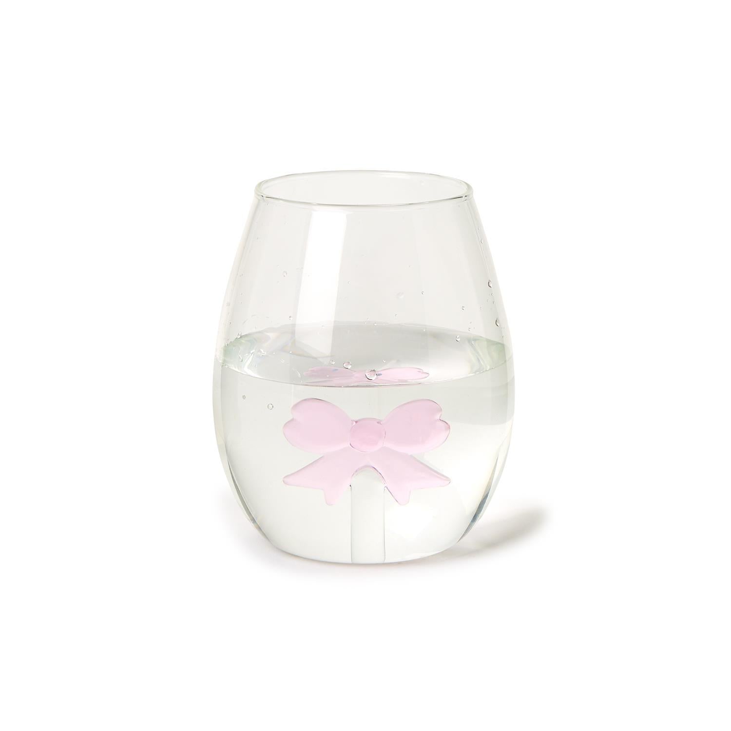 The Bow Stemless Wine Glass, highlighted by a pink bow-shaped ice cube, offers elegance and sophistication. Available sizes: 12 oz, 16 oz.