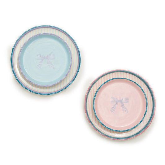 Two sets of trinket dishes made from durable stoneware. Each set includes three plates: one blue with stripes and a bow design, and the other pink, both featuring pastel artisanal looks. Available sizes: Small, Medium.