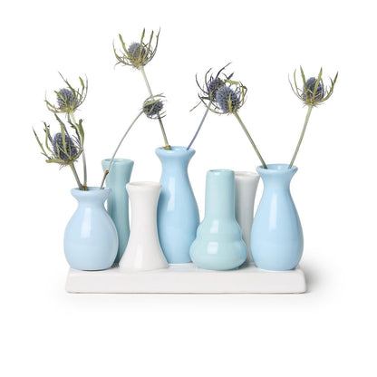 Porcelain vases in pastel blues and whites, each with a spiky flower. Set on a white rectangular tray. Sizes available: 7 sections.
