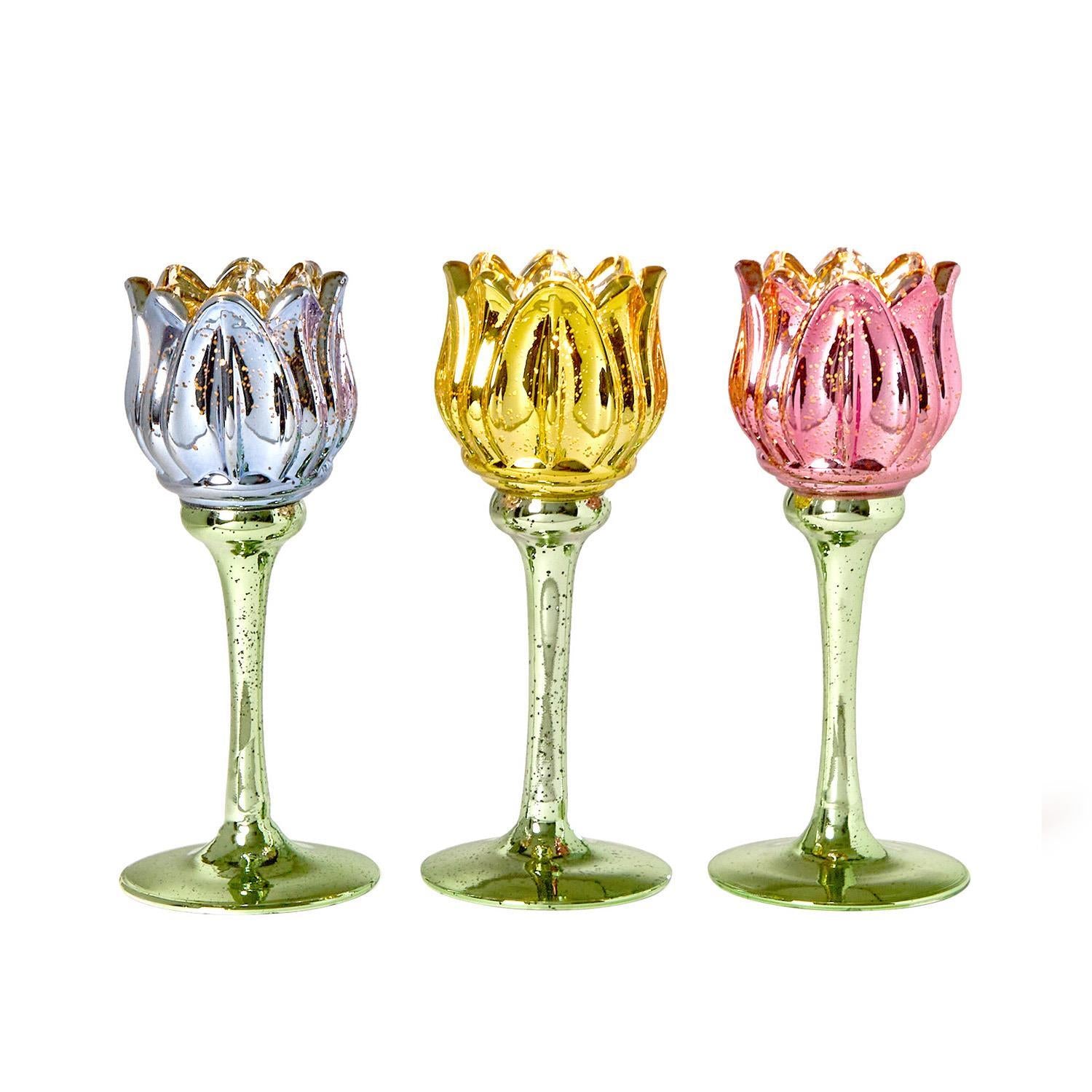 Set of three tulip stemmed tealight candleholders in silver, gold, and pink. Available in three colors; sizes not specified.