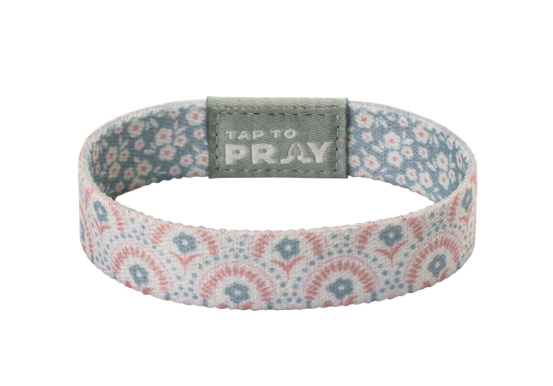 Tap To Pray™ Wristbands - Boho, featuring a pink and blue floral elastic band with a grey “TAP TO PRAY” embossed tab.