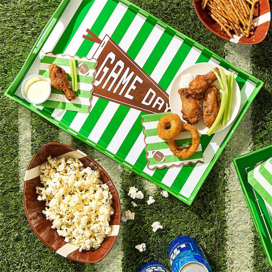 Game Day Decorative Handled Serving Tray, sold separately, with handles and striped field design. Available sizes: [sizes not specified]. Shown holding chicken wings, onion rings, celery, dip, and napkins.