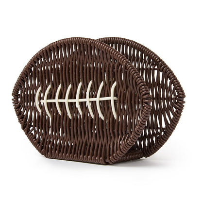 The Game Day Football Napkin Holder is a brown woven basket shaped like a football with white lace-like accents on the front, available in multiple sizes.