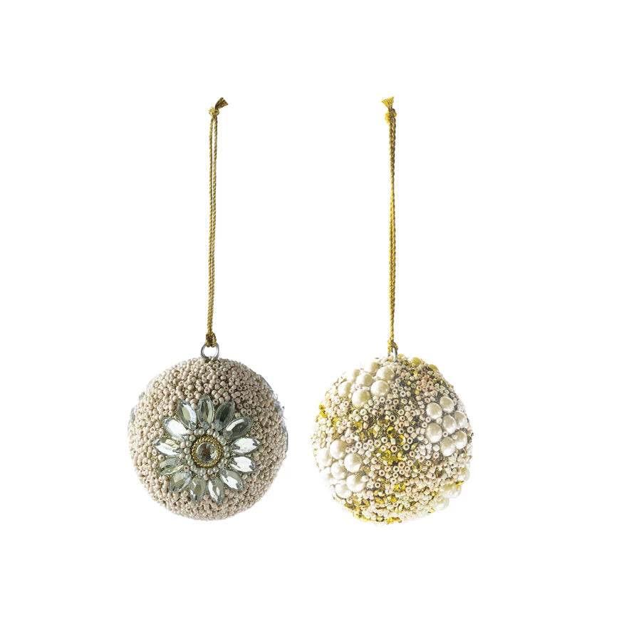 Two round ornaments with beads, sequins, and jewels, one with a floral design and the other covered in pearls.
