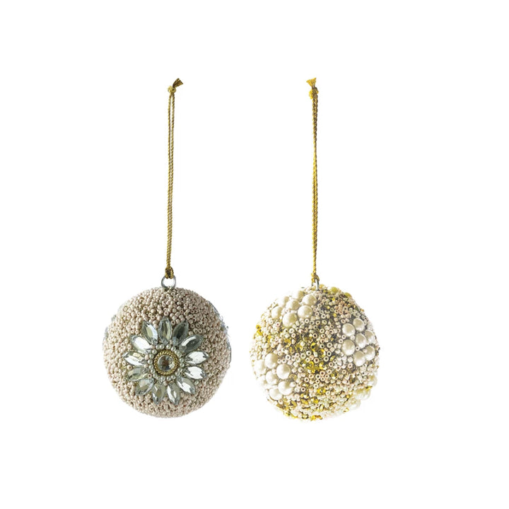Two round ornaments with beads, sequins, and jewels, one with a floral design and the other covered in pearls.