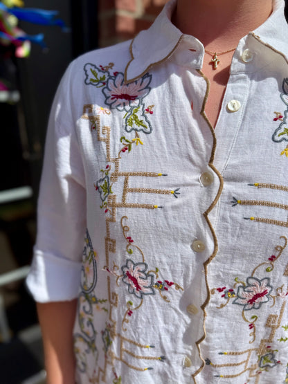 White Table Linens Dress with floral embroidery, gold trim, white buttons. Available in sizes XS-XL.