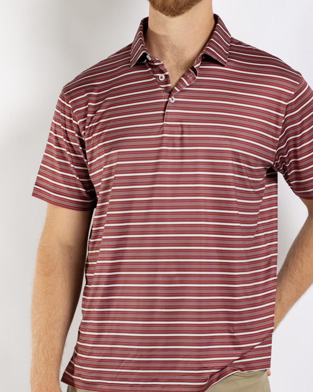 Men’s Maroon Sideline Striped Polo with short sleeves and horizontal red, white, and pink stripes. Available in sizes S-XXL.