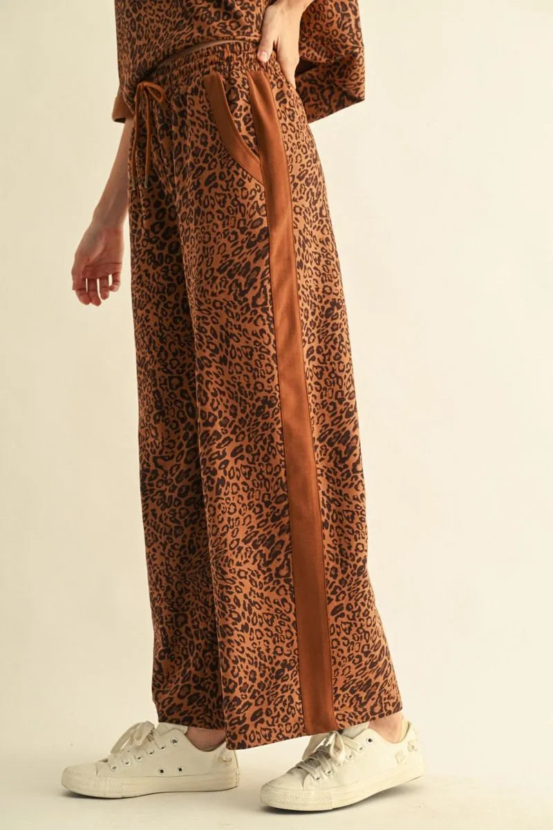 Leopard Contrast Pants: loose, brown leopard print with drawstring waist and solid brown side stripe. Available in sizes XS–XL.