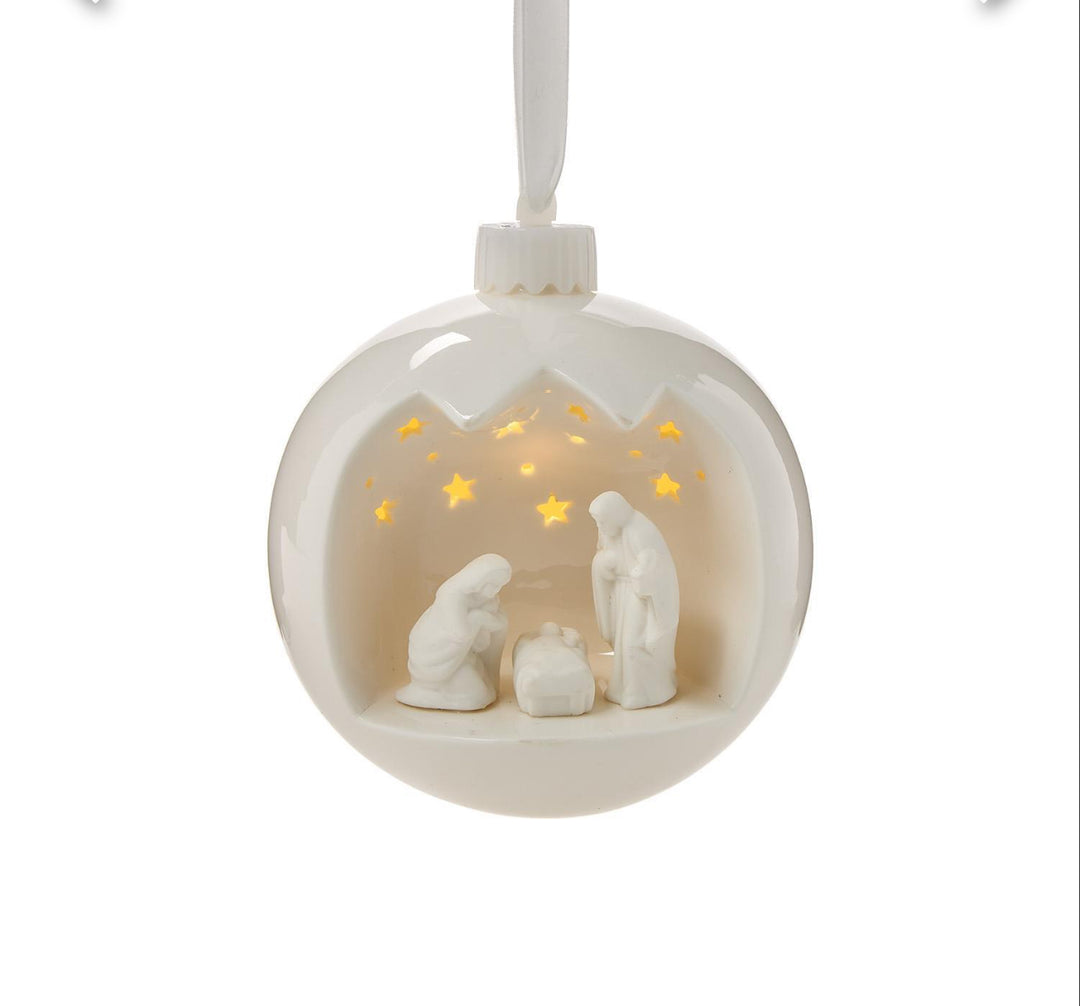 Light-Up Porcelain Nativity Ornament with Stand, featuring an internal nativity scene and star-shaped cutouts.