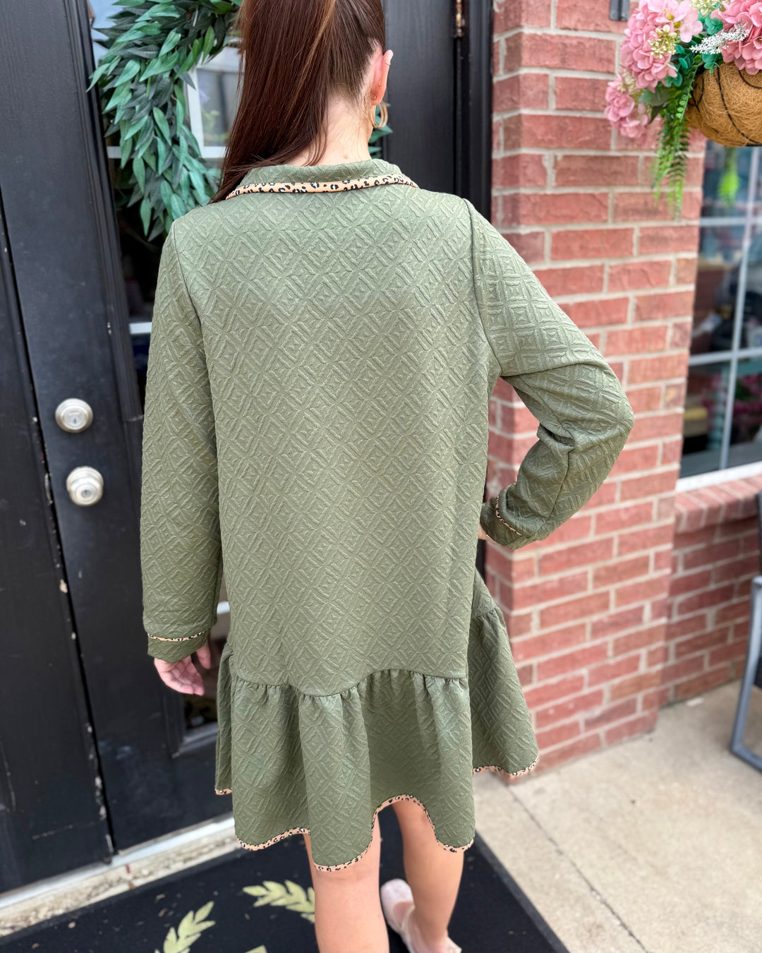 Adriana Olive Dress: textured geometric pattern, long sleeves, ruffled hem; available in sizes XS–XL.