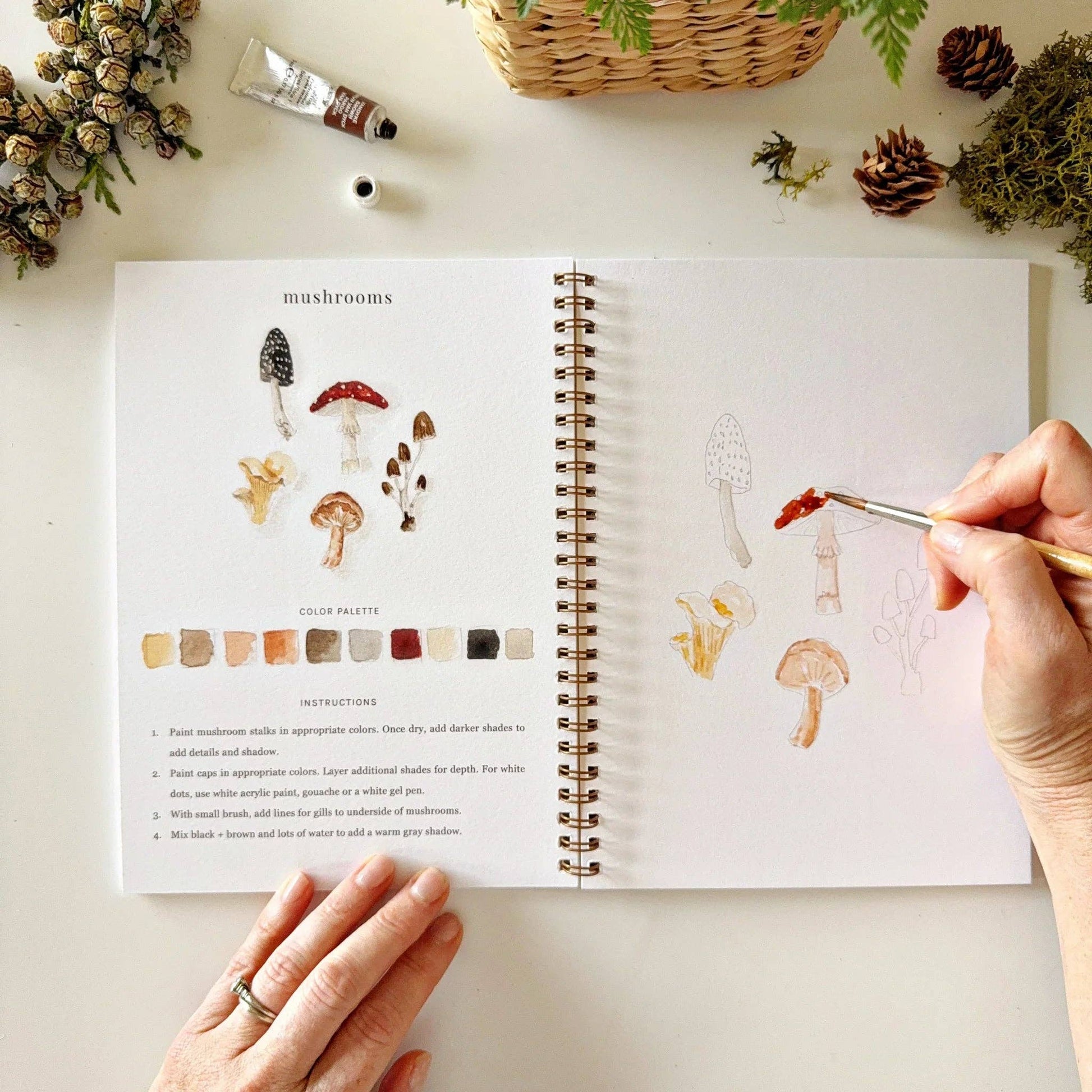 The Woodland Watercolor Workbook features a mushroom color palette and step-by-step painting instructions. Available sizes: 8x10 inches, 9x12 inches.