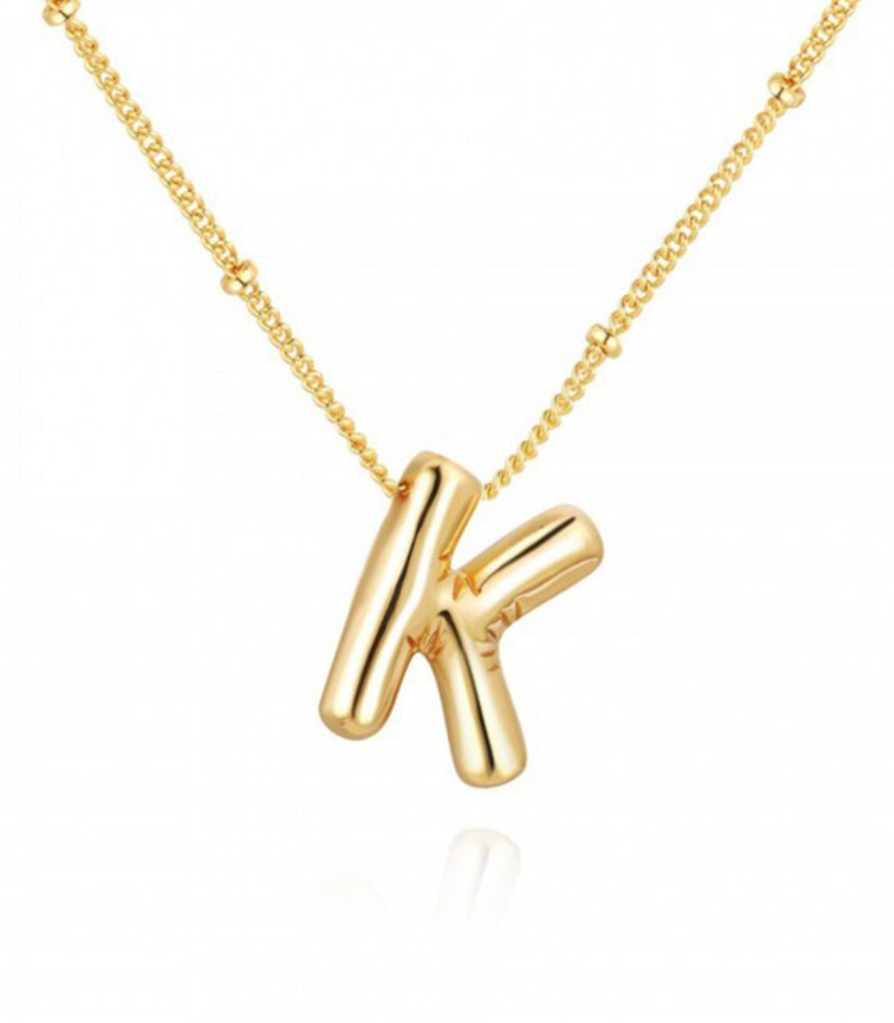 This is a Personalized Bubble Balloon Initial Necklace featuring a high-gloss bubble letter "k" pendant. It's delicately hung on a bead chain. The little bead spacing adds an understate elegance to the piece, making it perfect for daily wear. Available in various sizes to cater different personal preferences.