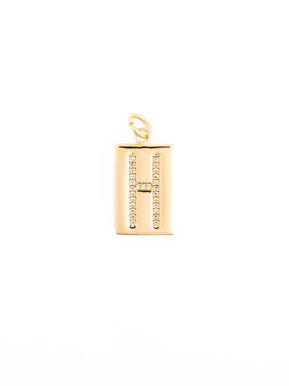Customizable gold rectangular pendant with pavé crystal letter “H,” small attachment loop, hypoallergenic 18k gold-plated material. Available sizes: small, medium, large.