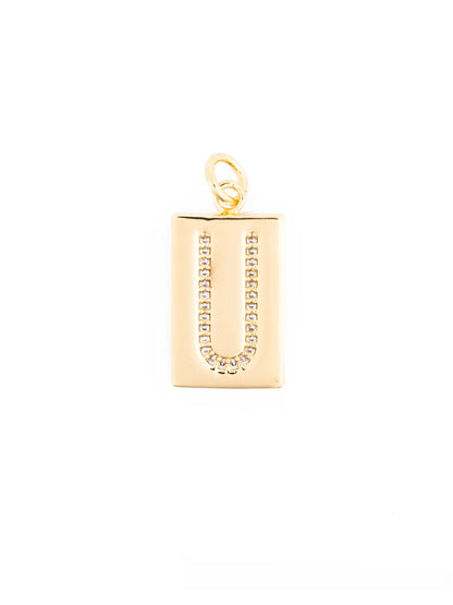 Thea Charm Bar: 18k gold plated rectangular pendant necklace with letter “U” outlined in clear stones and a top loop for attachment. Available in multiple sizes.