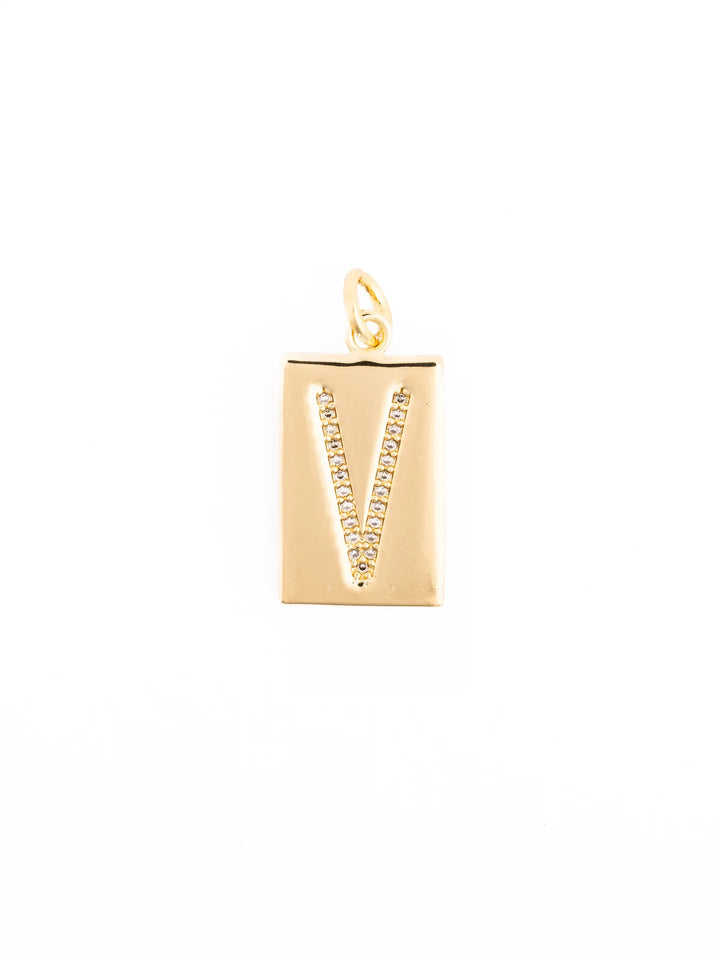 Thea Charm Bar: gold rectangular pendant with letter “V,” clear sparkling stones, 18k gold-plated, loop for attachment. Available sizes: Small (1”), Medium (1.5”), Large (2”).