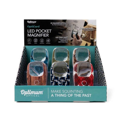 Six Optimum Optical The Hobbyist OptiCard LED Pocket Magnifiers in assorted colors and patterns, each with 2X magnification and a built-in LED light. Sizes available: pocket-sized. Text on packaging: “Make squinting a thing of the past.”.
