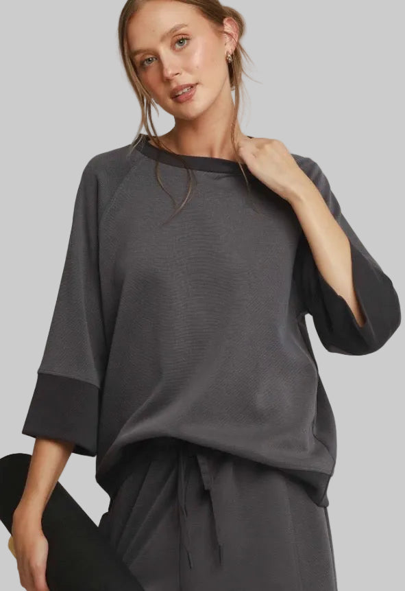 Charcoal colorblock raglan top in charcoal CloudKnit with solid black neck and cuff trim. Available in all sizes.