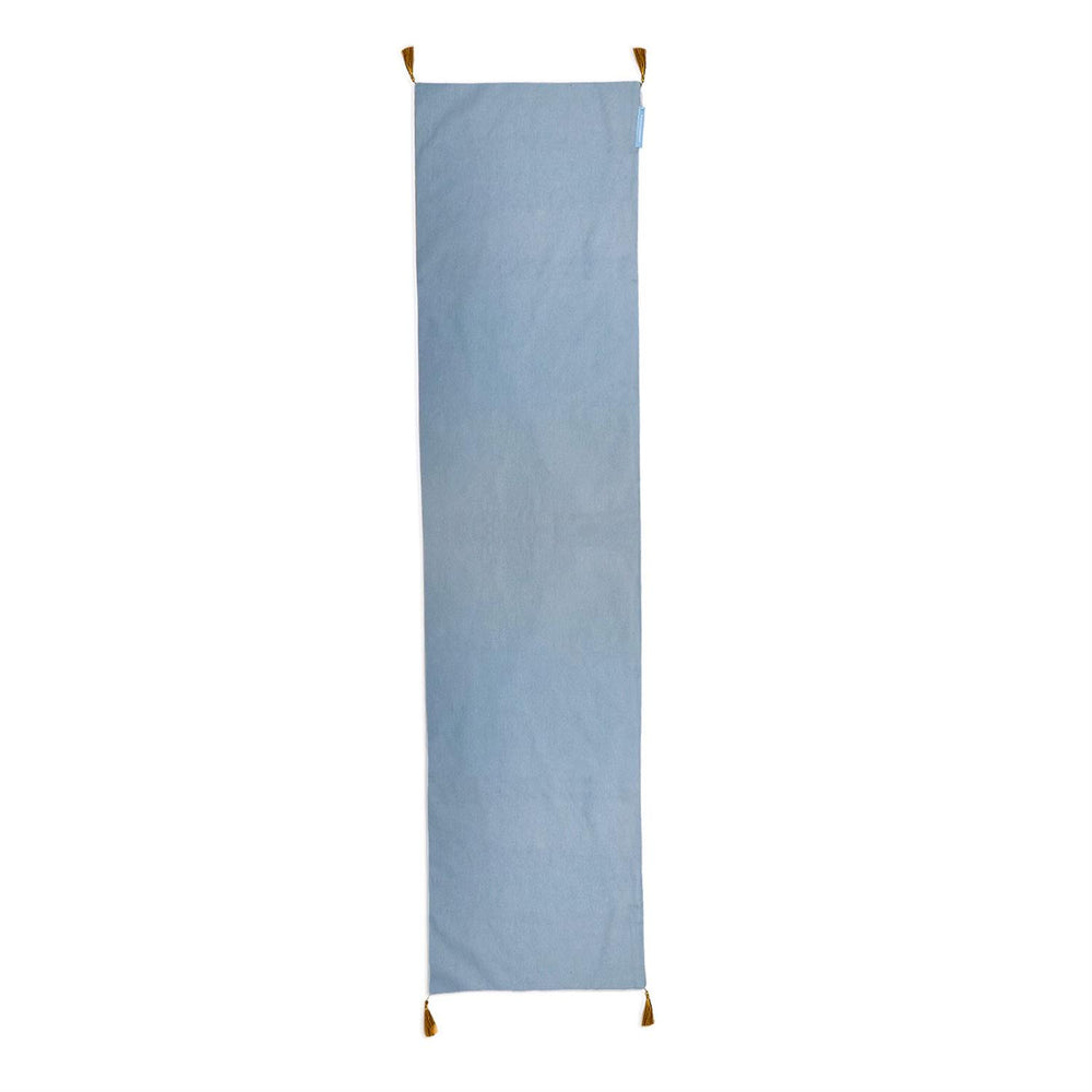 Light blue rectangular Gilded Cottage double-sided table runner with gold corner tassels.