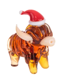 Amber-colored glass Highland cow figurine with a red and white Santa hat.